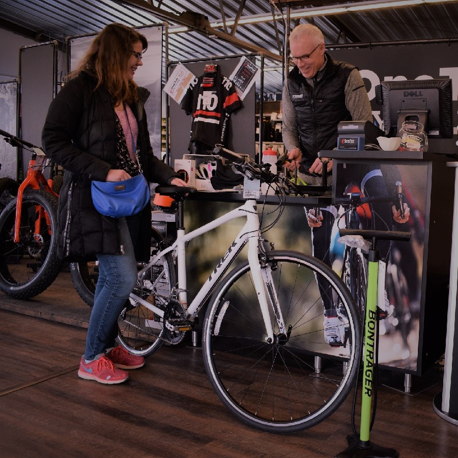 A rider being fitted for a rental bike at a local shop counter